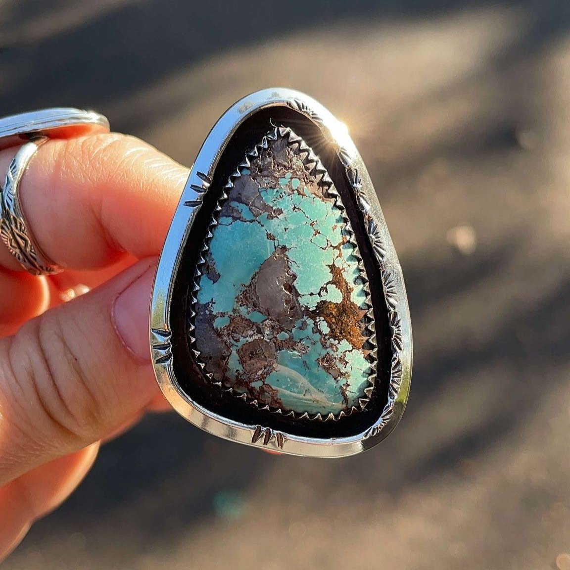 Large Kingman turquoise set in shadowbox setting on split shank ring band. Hand stamped designs.